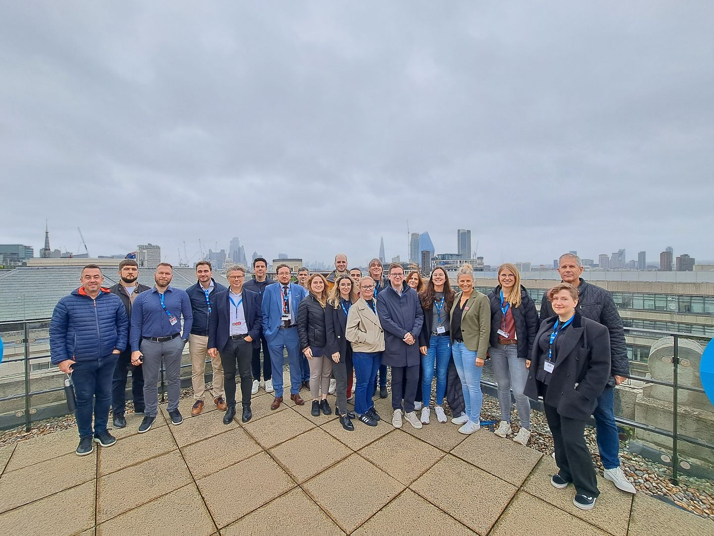 Eine Gruppe Menschen auf eine Dachterrasse, mit Londs City Skyline im Hintergrund