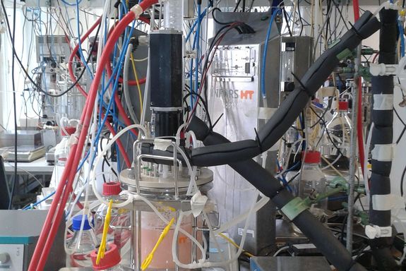Im Vordergrund der Bioreaktor, im Hintergrund ein Display, das gemessenen Werte anzeigt.