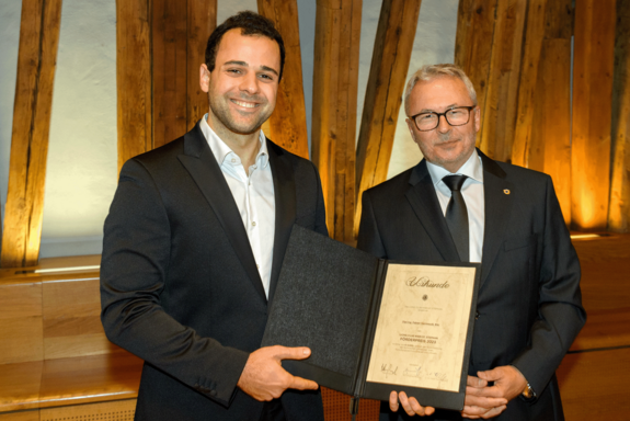 Fabian Garmroudi bei der Überreichung des Lions Förderpreises. Er hält die Urkunde in Händen.