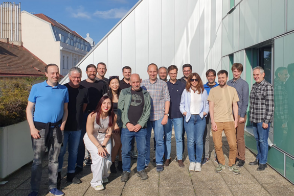 A group of 17 persons standing on a roof deck.