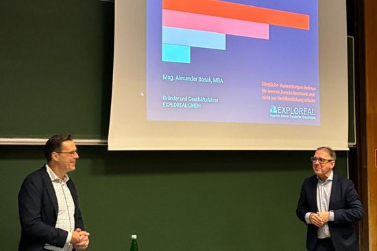 Alexander Bosak und Bob Martens in Hörsaal vor Tafel bzw. Präsentationsprojektion