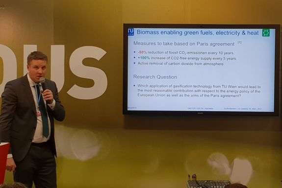 Dr. Stefan Müller (TU Wien) infront of Flatscreen presenting "Biomass enabling green fuels, electricity and heat"
