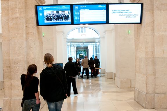 Aula Screens Eingangsbereich mit Informationsbildschirmen, die im Gang platziert sind.
