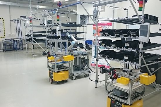 Mechanical engineering laboratory. Shelves full of individual parts and a machine being built.
