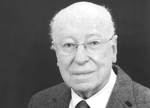 Scwarzweiß-Bild des älteren freundlich wirkenden Herrn mit kurzen Haaren, Brille und im Anzug.