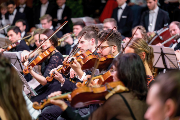 Streichmusiker_innen in festlicher Kleidung.