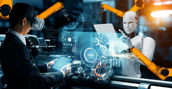 Eine futuristische Industrieszene, in der ein Mensch mit einem Virtual-Reality-Headset zusammen mit einem humanoiden Roboter arbeitet. Der Mensch interagiert mit fortschrittlichen digitalen Schnittstellen, die auf transparenten Bildschirmen angezeigt werden, während der Roboter Maschinen präzise bedient. Beide arbeiten in einer Hightech-Umgebung, die durch Roboterarme, Datenvisualisierungen und digitale Systeme gekennzeichnet ist und die Synergie zwischen menschlicher Intelligenz und robotischer Automatisierung symbolisiert.