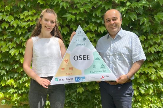 Two people holding a board saying "OSEE"
