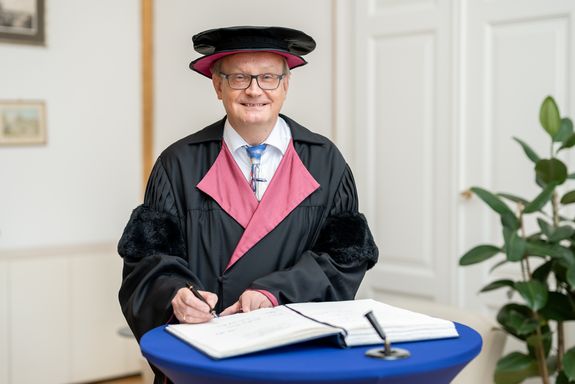 Gernot Tragler unterschreibt im Ehrenbuch der TU Wien