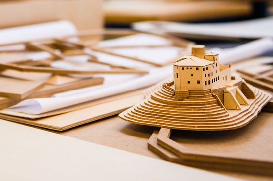 A model of a house on a mountain, made of cardboard.