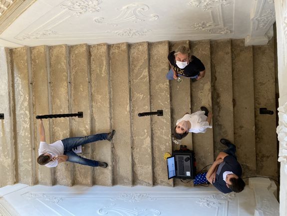Studierende der TU Wien mit Corona-Schutzmasken auf der Treppe des Schlosses. 