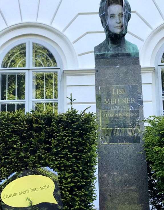 Büste eines berühmten Wissenschaftlers mit Maske und Namen der Atomphysikerin Lise Meitner verkleidet.