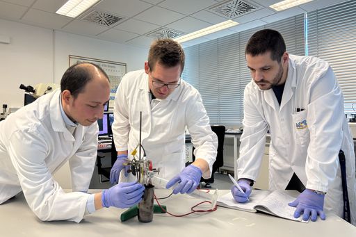 three scientists in white lab coats
