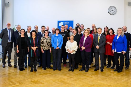 Gruppenbild in einem Innenraum mit Parkett mit etwas mehr als 30 Personen