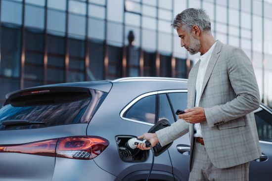 Mann lädt ein Auto auf.