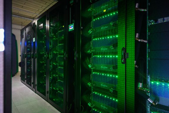 Detailansicht VSC-5, mehrere Racks mit Kabeln und grün leuchtenden LEDs