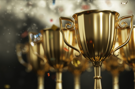 Hintereinander aufgereihte Pokale und Konfetti-Regen