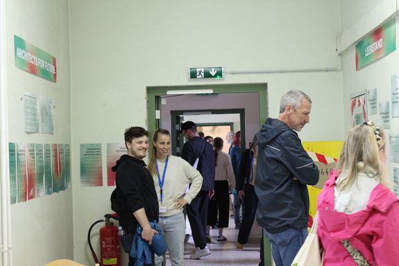 Menschen stehend, schauen Exponate und Plakate an