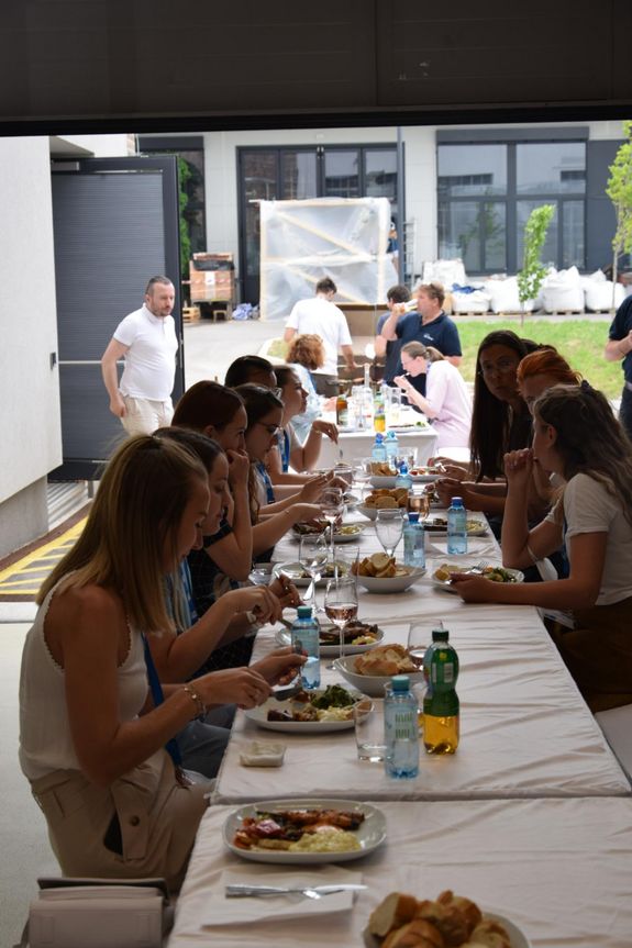 Menschen essen an einem langen Tisch