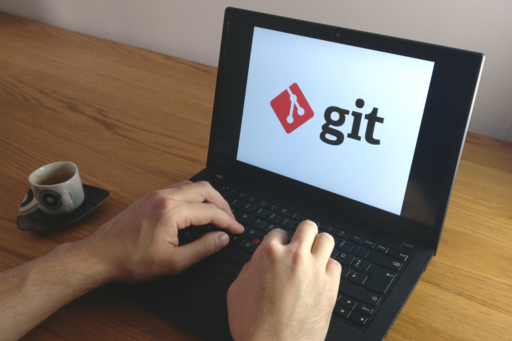 Hands typing on a laptop keyboard, on the screen the git icon.