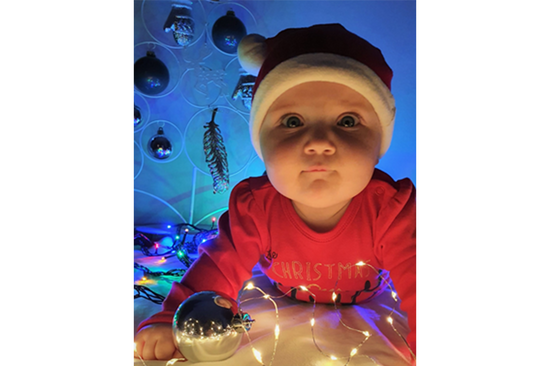 Baby with Christmas decoration and Santa hat