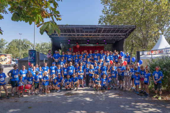 Gruppenfoto der Läufer_innen mit TUW-T-Shirt vor einer Bühne.