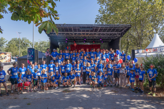 Gruppenfoto der Läufer_innen mit TUW-T-Shirt vor einer Bühne.