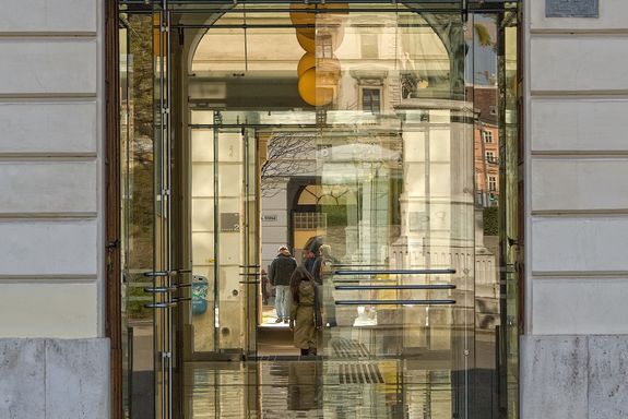 Hauptgebäude alter Eingang Eingangstür aus Glas mit einem runden Abschluss oben.