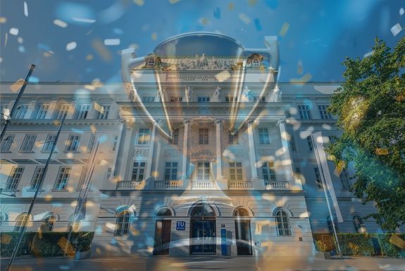 Frontansicht des TUW-Hauptgebäudes - darübergelegt ein Pokal mit Konfetti