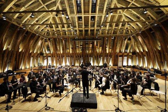 Academic Wind Philharmonic Orchestra Vienna Orchestra with a conductor in the middle in the domed hall of the TU Vienna.