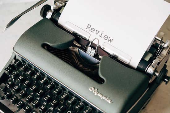 Typewriter with a sheet titled Review