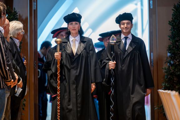 Bedels in academic ceremonial dress: black cap, black cape and scepter