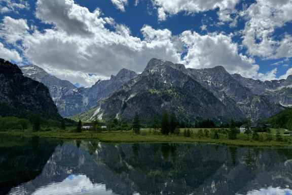 See, Berge, Himmel. Die Berge spiegeln sich im See. 