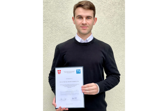 Der Preisträger präsentiert seine Urkunde.