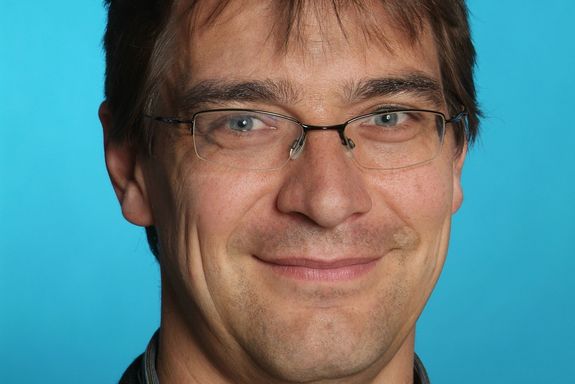 Karsten Held Portrait photo of Karsten Held on the bright blue background