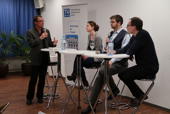 Blick auf das Podium. Von links nach rechts: Norbert Fiala (Moderator), Elisabeth Gruber, Florian Libisch und Thomas Müller. Im Hintergrund steht ein TU Wien Roll-Up.