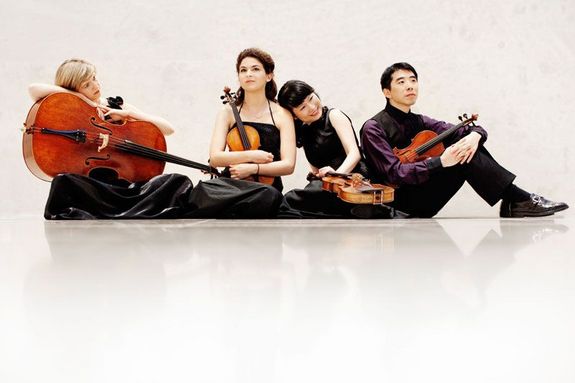 Jeunesse Vier Musiker sitzen mit ihren Instrumenten am Boden