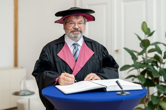 Joachim Schöberl unterschreibt im Ehrenbuch der TU Wien