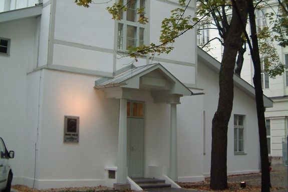 Luftpavillon Zweigeschossige Gebäude im Hof. Es hat ein Satteldach und eine weiße Putzfassade. Beide seitliche Teile haben nur einen Geschoss.