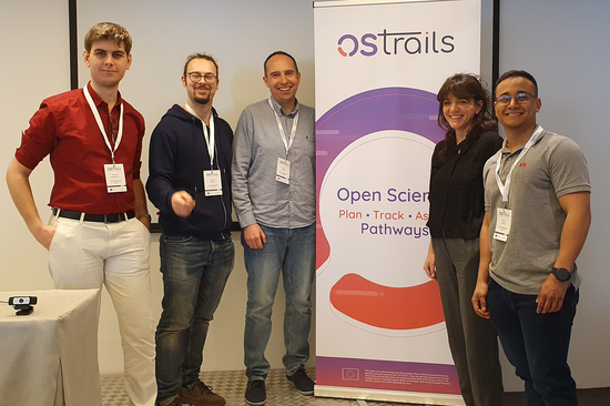 Das Foto zeigt fünf Personen, die neben einem Aufsteller des OSTrails Projektes stehen.