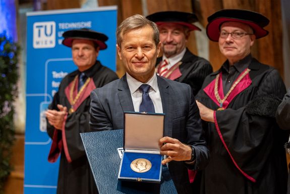 Ferenc Krausz präsentiert die Prechtlmedaille. Im Hintergrund Würdenträger der TUW