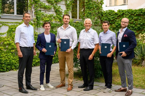 Gruppenfoto der Preisträger_innen vor einer begrünten Hauswand. 