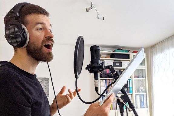 Chormitglied bei der Gesangsaufnahme im Tonstudio zu Hause