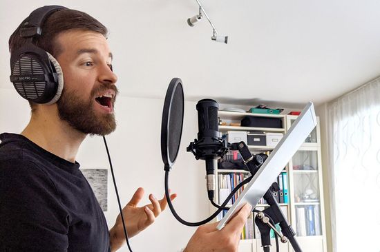 Chormitglied bei der Gesangsaufnahme im Tonstudio zu Hause