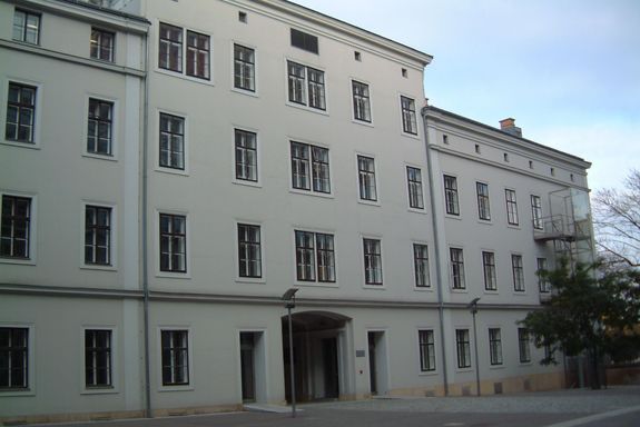 Geniegebäude Ein Haus mit einer Putzfassade und vier Stockwerken.