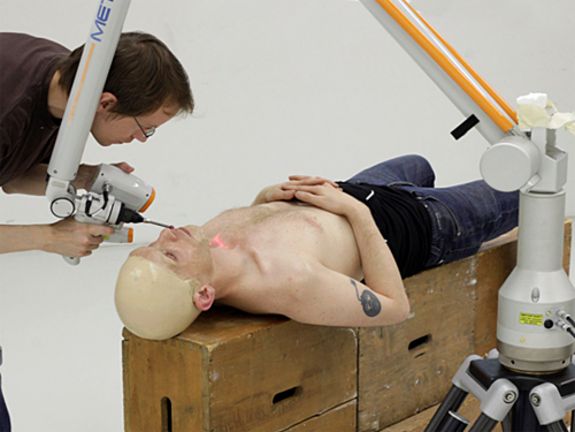 Florian Rist justiert den Laser-Scanner, mit dem TOMAKs Kopf gescannt wird.