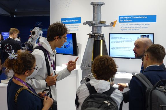 Florian Donner talking to four young visitors about the helicopter drivetrain