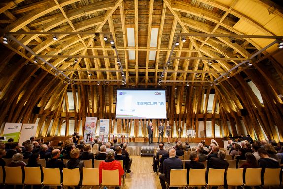 General view of the domed hall from the back row with podium and audience.