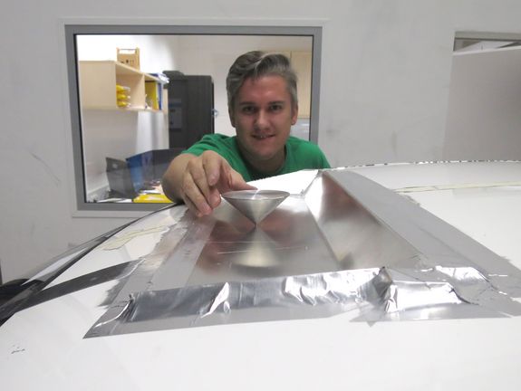 [Translate to English:] Gerald Artner installiert eine Probe-Antenne am Autodach