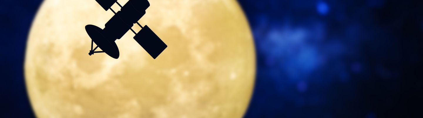 Ein Satellit schwebt vor dem Mond vorbei